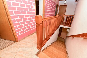 Eine Holztreppe mit einer roten Backsteinmauer und einer weißen Tür.
