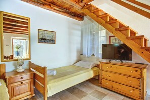 Ein Schlafzimmer mit einem hölzernen Bett, einem Schminktisch, einem Fernseher, einem Gemälde und einem Fenster mit Vorhängen.