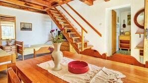 A wooden dining table with a vase and a red bowl, a wooden staircase, and a painting on the wall. - Apartment 2440/244326 (Kvarner - Martinšćica), 200m from the beach (Martinšćica)