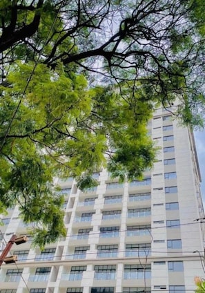Um edifício de vários andares com design arquitetônico moderno, com uma série de varandas e janelas.