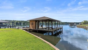 A gazebo-style structure with a roof and walls, situated on a dock extending into a calm lake. - Lake Sinclair Paradise|Beach|Game Rm|Dog-Friendly (Eatonton)