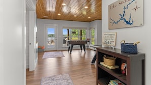 A spacious room with a wooden ceiling, a pool table, and a view of a lake. - Lake Sinclair Paradise|Beach|Game Rm|Dog-Friendly (Eatonton)