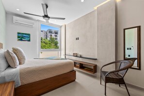 Ein Schlafzimmer mit Bett, Stuhl, Fernseher und Fenster mit Blick.