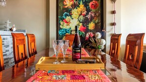 A dining table with a bottle of wine, two glasses, and a tray. - 5 min to the center! | Beautiful and homely | Incredible views & private parking (Cusco)