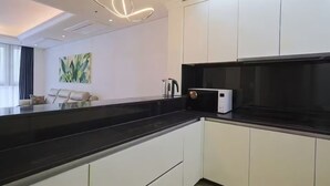 Une cuisine moderne avec des armoires blanches, un comptoir noir et un four à micro-ondes.