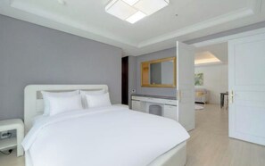 A modern bedroom with a large bed, a bedside table, a mirror, and a wardrobe. - BS centum hotel (Busan)