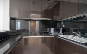 A modern kitchen with stainless steel appliances, a built-in oven, and a sink. - BS centum hotel (Busan)