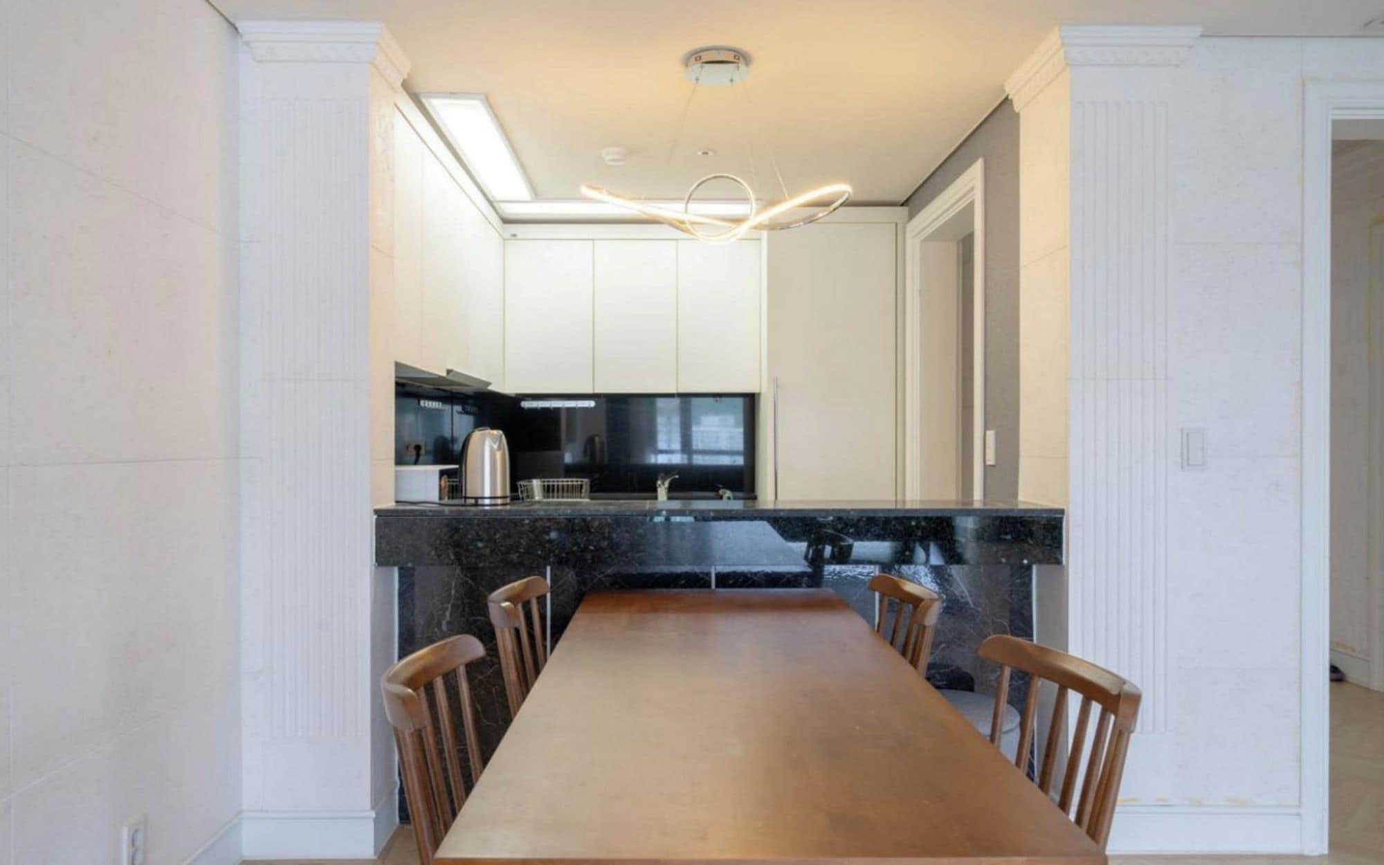 A modern kitchen with a dining area.