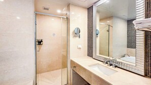 A modern bathroom with a glass shower enclosure, a large mirror, and a sink with a vanity. - BS centum hotel (Busan)