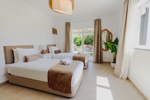 A hotel room with a large bed, two bedside tables, a mirror, and a potted plant. - Villa Ursa | 6 bedrooms | Jacuzzi | Benagil (Carvoeiro)