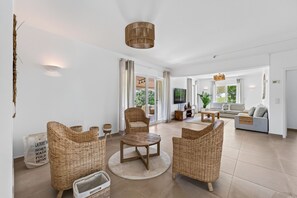 A spacious living room with a large sofa, a coffee table, and wicker furniture. - Villa Ursa | 6 bedrooms | Jacuzzi | Benagil (Carvoeiro)