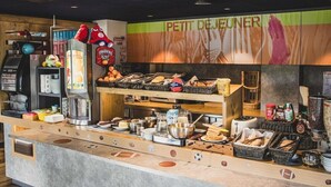 A breakfast bar with various food items and a coffee machine. - Ibis Budget Dijon Saint Apollinaire (Saint-Apollinaire)