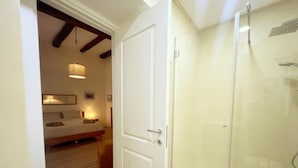 Une chambre à coucher avec un lit, une table de chevet et un luminaire suspendu.