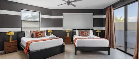 A modern hotel room with two beds, a ceiling fan, a large window with curtains, and a view of the outdoors.