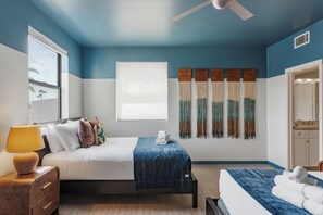 A hotel room with a bed, a desk, a chair, a window, a ceiling fan, and a bathroom visible through an open door. - Vega - Private Balcony - In Old Town Scottsdale (Scottsdale)