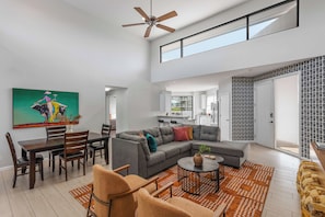 A spacious living area with a dining table, sofa, and a ceiling fan. - Zeta - Private Balcony - In Old Town Scottsdale (Scottsdale)