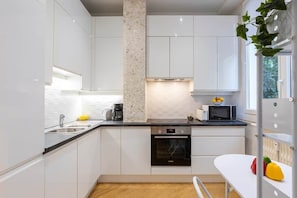 A modern kitchen with white cabinets, a built-in oven, a microwave, and a coffee maker. - Promenade Flat for 3 Guests | 30+ Night Stay (Nice)