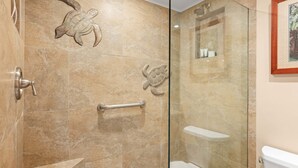 A bathroom with a glass shower enclosure, a handrail, and a framed picture on the wall. - New Listing Lahaina Shores 412 Beach Front Resort (Lahaina)