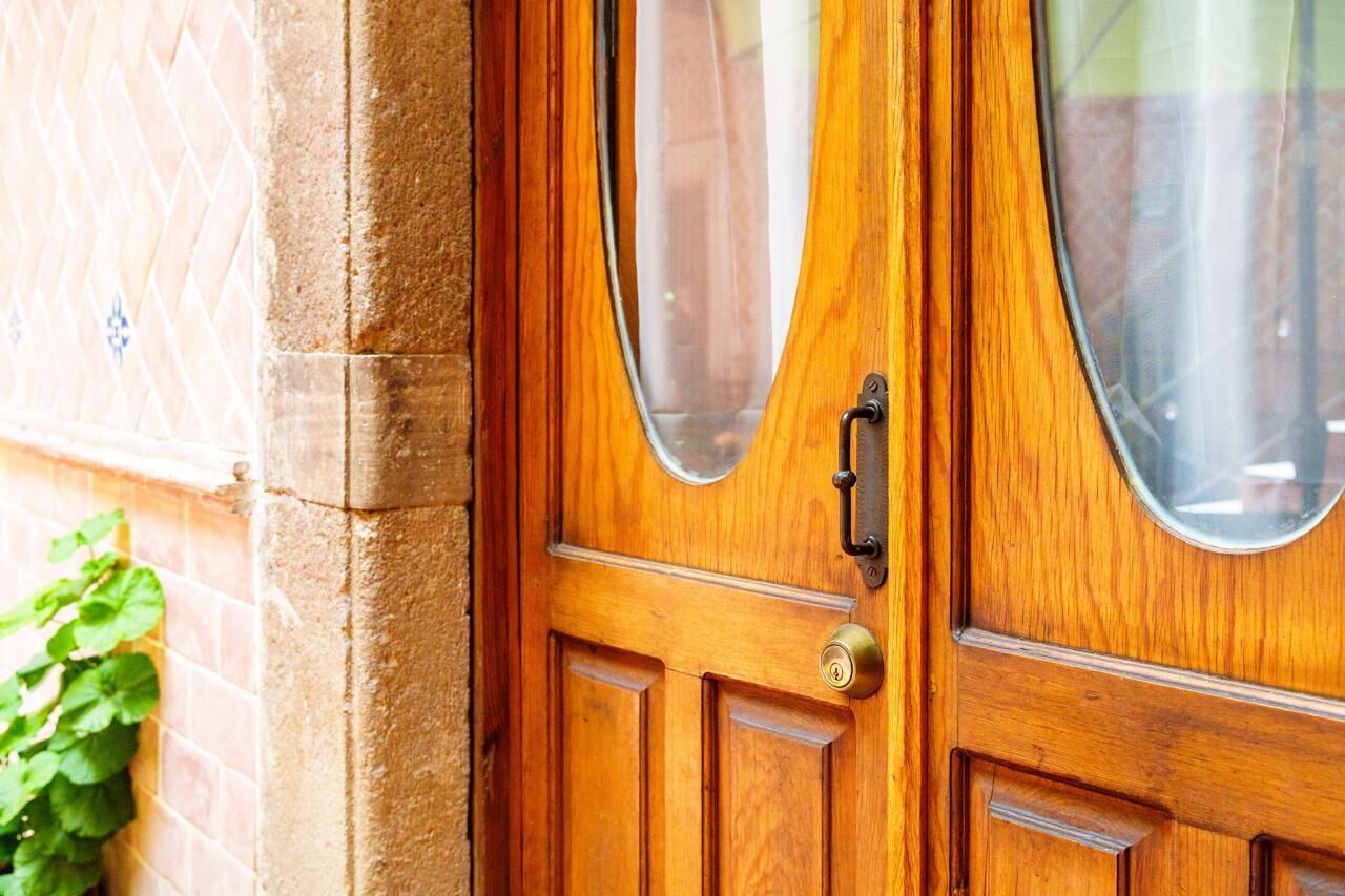 A wooden door with a brass handle and a keyhole.