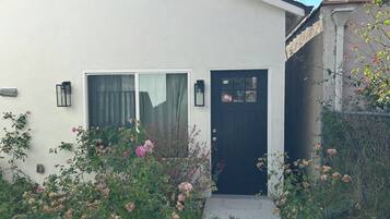 A house with a black door, a window with a curtain, and a small porch.