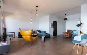 A modern living room with a sofa, a yellow chair, a coffee table, and a lamp. - T4 apartment with incredible views! Sea view, route des sanguinaires (Ajaccio)