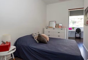A bedroom with a bed, a desk, a chair, a dresser, and a window. - T4 apartment with incredible views! Sea view, route des sanguinaires (Ajaccio)