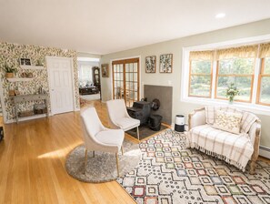 A spacious living room with a fireplace, a dining area, and a kitchen. - FIFA World Cup Stay • Whole House • 21 Miles to Gillette Stadium (Hanover)
