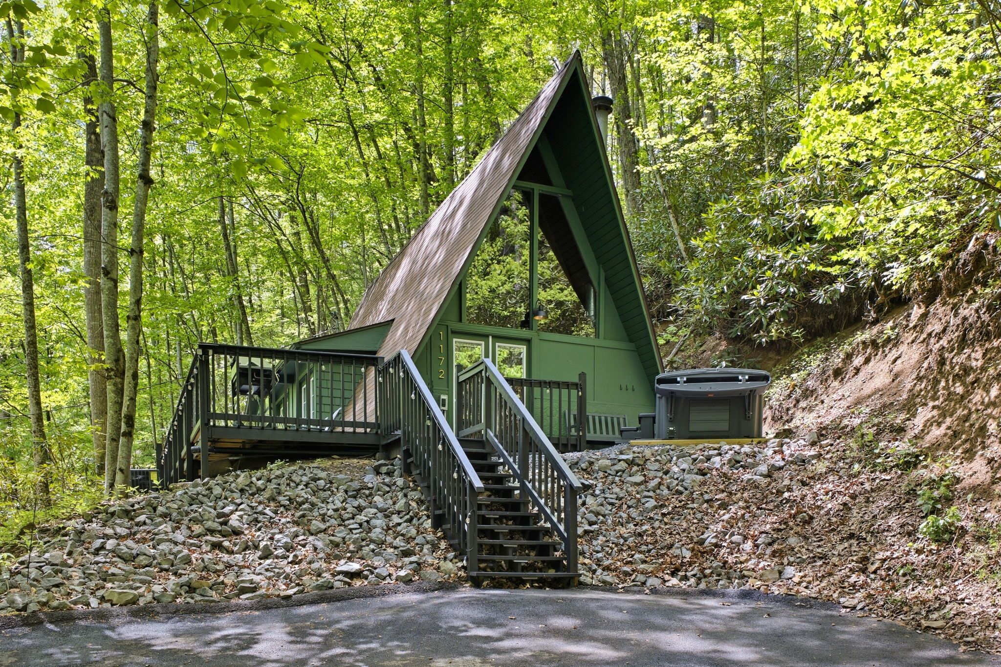 A cabin with a steep staircase, surrounded by a forest.
