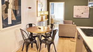 A modern kitchen with a dining area, a sofa, and artwork on the walls. - Broadway (San Diego)