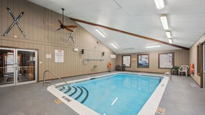 A swimming pool with no diving signs, a ceiling fan, and a lifeguard sign on the wall. - Lies by Avantstay Indoor Heated Pool + Game Lounge Pool Table + Foosball (North Creek)