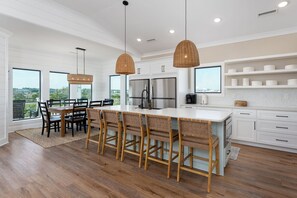 Una cucina moderna con isola centrale, mobili bianchi e vista sull'esterno.