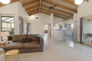 A spacious living area with a sofa, a round table, and a ceiling fan. - Cue the Views at Seven (Clifton Springs)