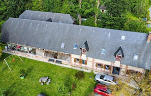 A two-story house with a sloped roof, a fenced yard, and a car parked in the driveway. - Lovely home in Saint Ouen du Breuil with sauna (Saint Ouen du Breuil)