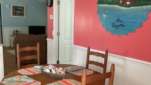A dining area with a round wooden table, cushioned chairs, and striped placemats. - Shellpoint in Townsend Ga. Spacious 3-bedroom mobile home lodge fee 129. a night (Townsend)
