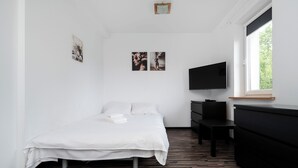 Une chambre d’hôtel avec un lit, un bureau, une télévision et une fenêtre.