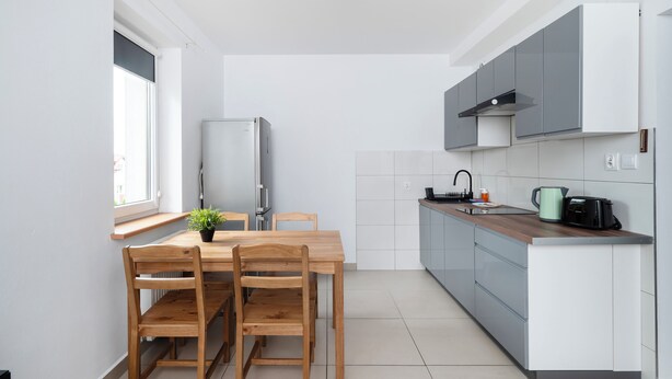 Une cuisine moderne équipée d’une table à manger, de chaises, d’un réfrigérateur, d’un évier et d’une cuisinière.