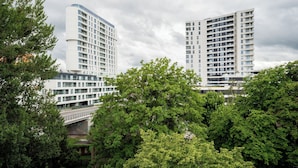 Two modern high-rise buildings with balconies, surrounded by lush green trees. - Gdynia Marina Harmony Apartment (Gdynia)