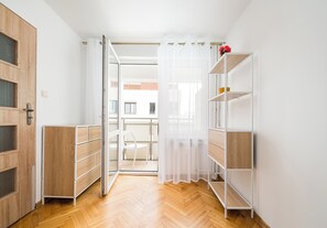 Ein Zimmer mit einem Holzkleiderkasten, einem weißen Schrank und einer weißen Regaleinheit.