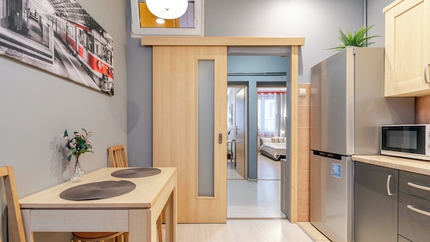 Eine kompakte Küche mit Mikrowelle, Kühlschrank und einem Essbereich mit Tisch und Stühlen.