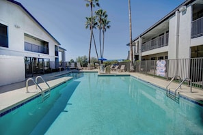 A swimming pool with a clear blue water, surrounded by a fence, and adjacent to a building with balconies. - Free Parking | Pet-Allowed | 3.0 mi to Santa Cruz River Walk Path (Tucson)