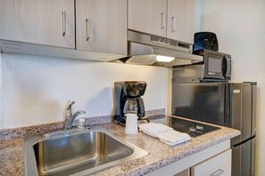 A kitchen with stainless steel appliances, a coffee maker, a microwave, and a sink. - Tucson Studio Getaway | Augie Acuna Los Ninos Park — 1 mile (Tucson)