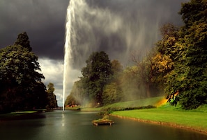 Eine friedliche Landschaft mit einem Gewässer, Bäumen und einem entfernten Wasserfall.