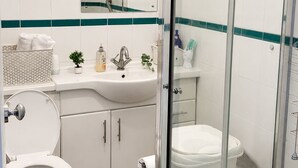 A bathroom with a toilet, sink, mirror, and shower area. - Studio - Sleeps 2 - Wifi - Parking (Dunstable)