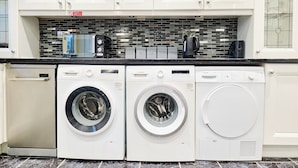 A kitchen with white cabinets, a tiled backsplash, and two Bosch washing machines. - House Sleeps 8 - Free Parking & WiFi (Birmingham)