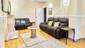 A living room with two leather sofas, a round coffee table, and a small side table. - House Sleeps 8 - Free Parking & WiFi (Birmingham)