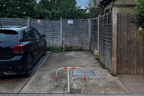 A parking area with a car and a metal barrier. - Cosy 1br Flat - 15mins to Central London (Croydon)