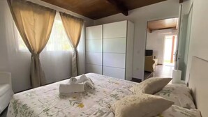 Een hotelkamer met een bed, gordijnen, een kledingkast en een bureau.