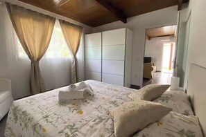 A hotel room with a bed, curtains, a wardrobe, and a desk. - Finca House by Fataga Maspalomas (San Bartolome de Tirajana)