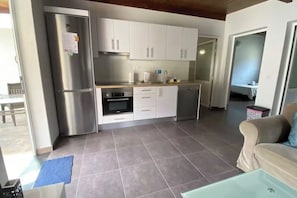 A modern kitchen with stainless steel appliances, white cabinetry, and a tiled floor. - Finca House by Fataga Maspalomas (San Bartolome de Tirajana)