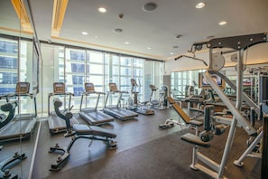 A gym with treadmills, elliptical machines, and weight equipment.